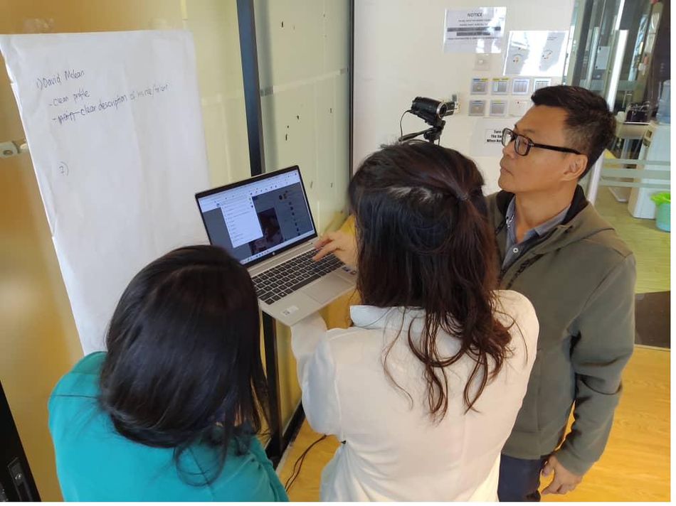 A small group working through a laptop together at the workshop