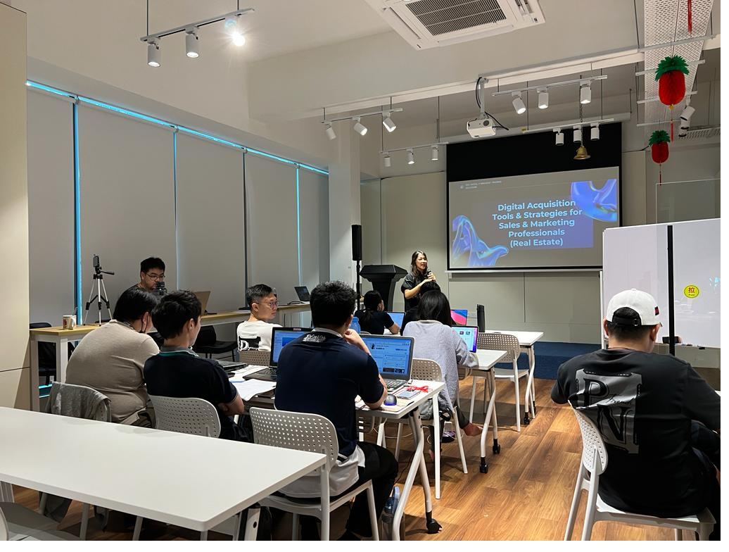 Stephanie Lam leading a live training session with participants working on laptops